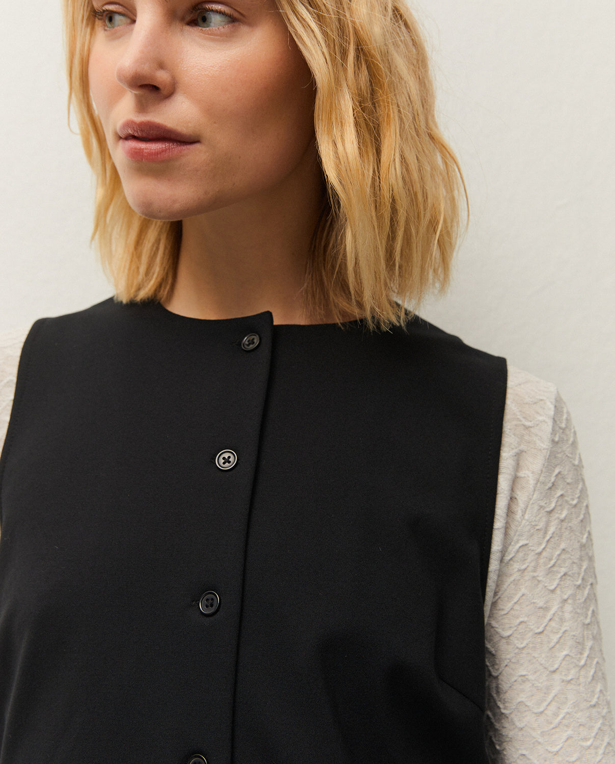 Chaleco negro con cuello caja, detalle de la prenda
